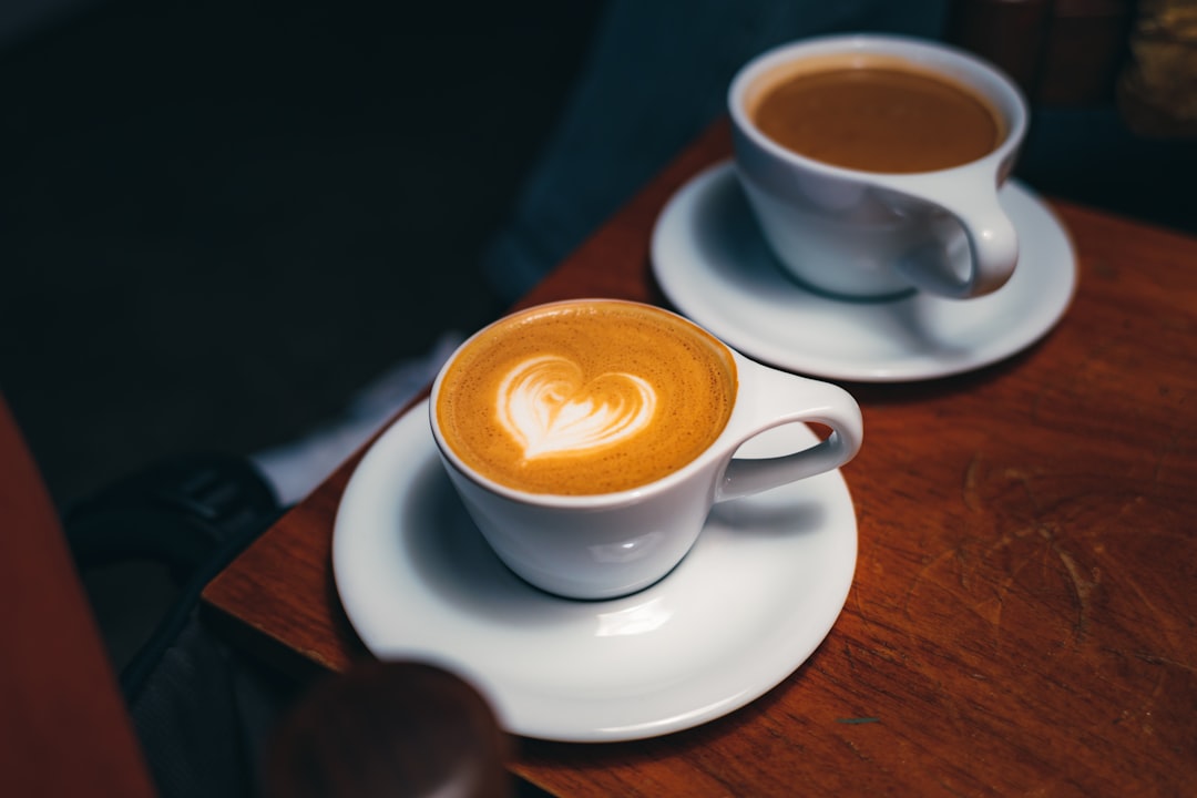 two-cups-of-coffee-sitting-on-top-of-a-wooden-table-wykez3gpdca